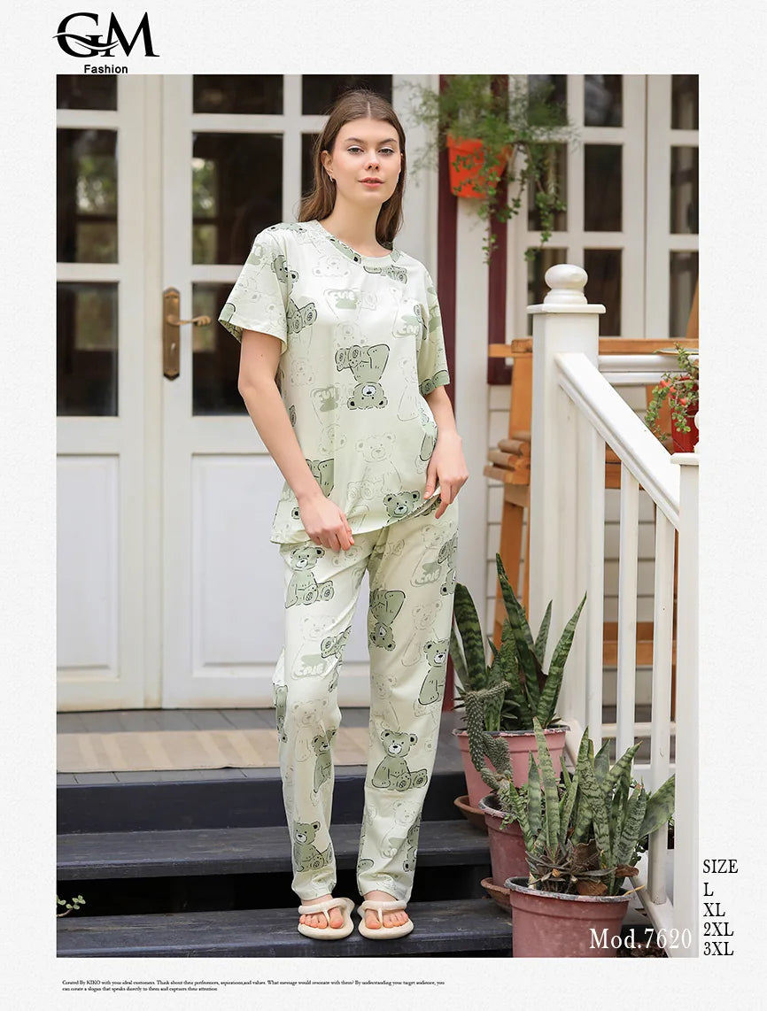 Woman wearing a patterned outfit standing on a porch with plants.