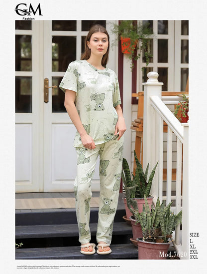 Woman wearing a patterned outfit standing on a porch with plants.