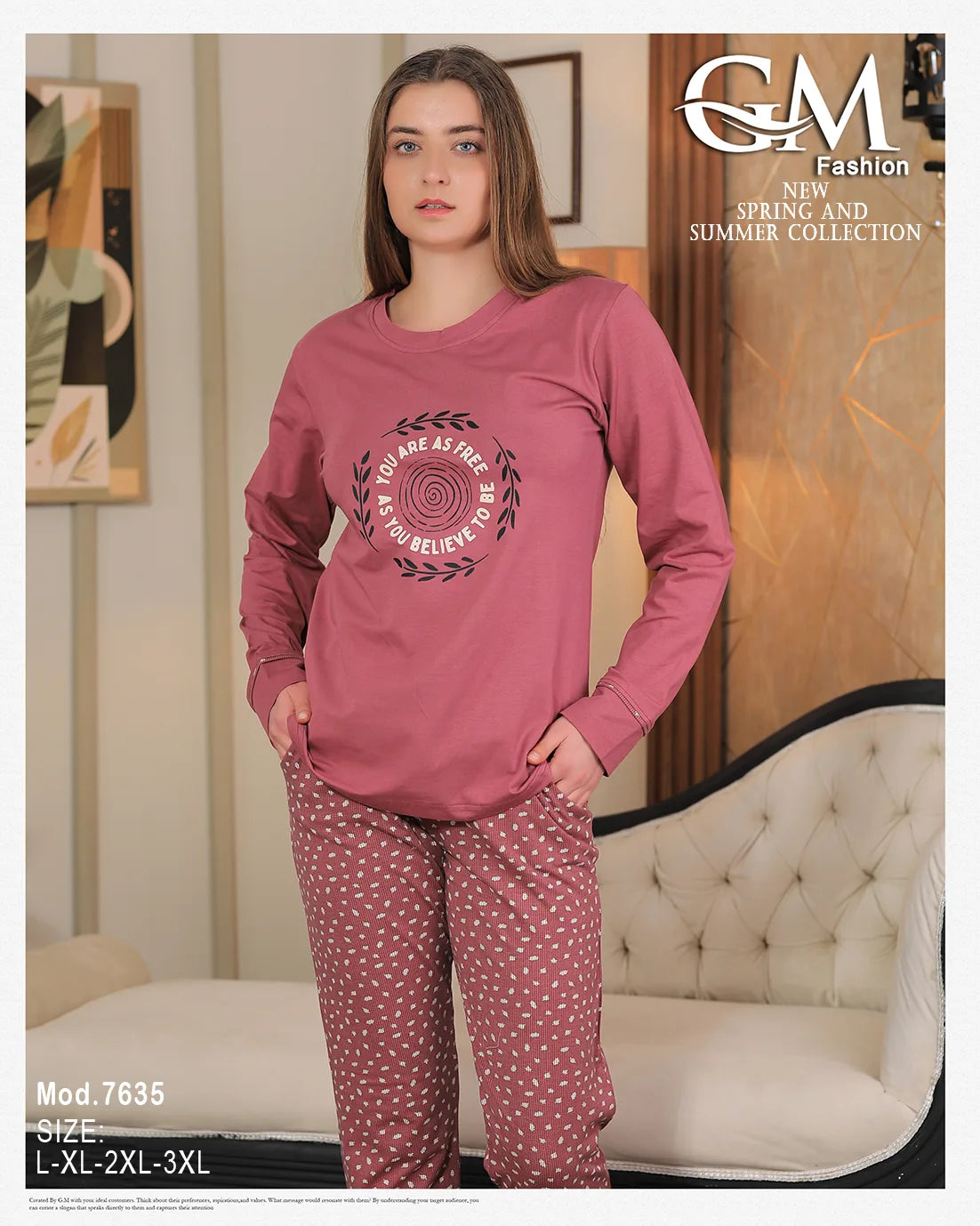 Woman wearing a pink long-sleeve top and patterned pants in a room with a couch and wall art.